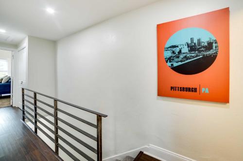 a staircase with an orange painting on the wall at Walk to Walnut St Pet-Friendly Pittsburgh Home! in Pittsburgh