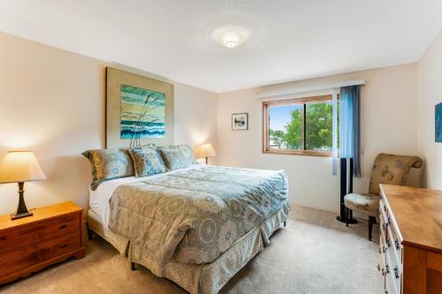a bedroom with a bed and a desk and a window at Lazy K on Peaceful Bay - Lake House in Lakeside