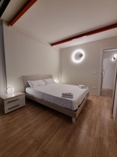 a white bedroom with a bed and a wooden floor at Comodo Loft Centro a Jesolo Lido - Free Beach place a 1 minuto!!! in Lido di Jesolo