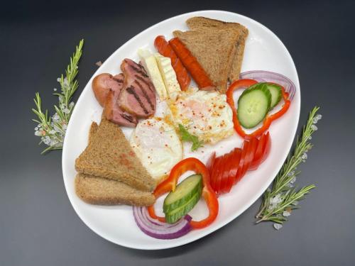 a plate of food with meat and bread and vegetables at Hotel Prestige in Alba Iulia