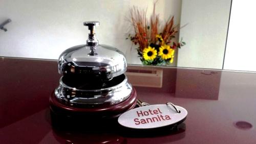 a coffee maker sitting on top of a counter with flowers at Hotel Sannita in Casoria