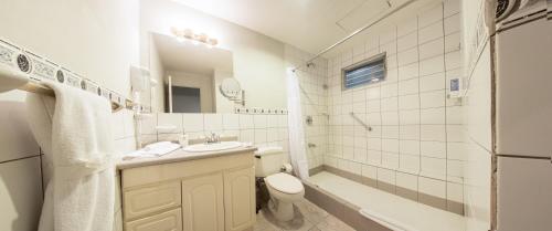 a white bathroom with a sink and a toilet at Apartotel Tairona in San Pedro