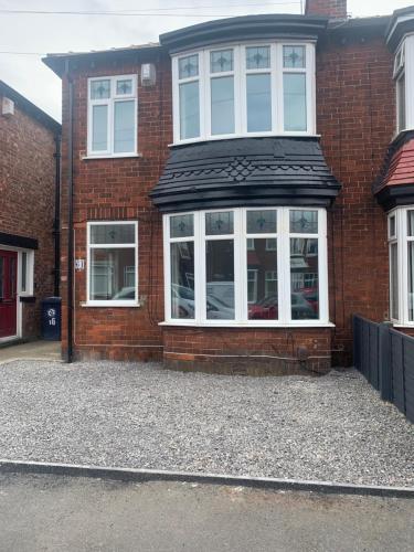 a red brick house with white windows and a driveway at Sandringham House in Redcar