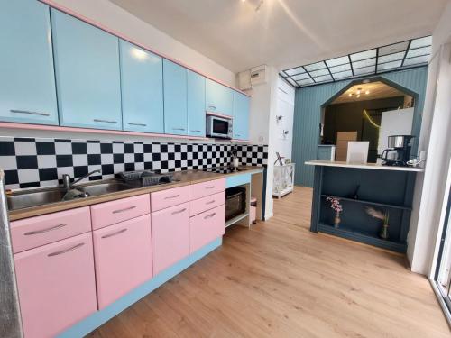 a kitchen with pink cabinets and a sink at Le Mc Fly in Hénin-Beaumont
