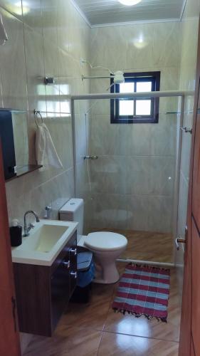 a bathroom with a toilet and a sink and a shower at Lar doce lar em Paraty in Paraty