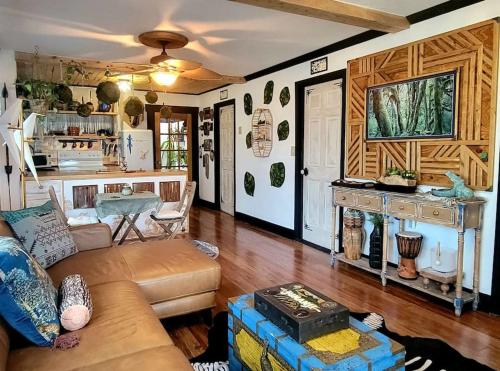 a living room with a couch and a table at Cozy AF Jungle-House Hideaway in Tampa