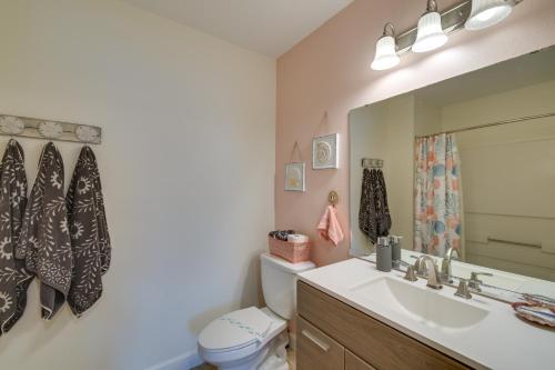 W łazience znajduje się umywalka, toaleta i lustro. w obiekcie Gulf Shores Condo with Pool Access, 5 Mi to Beach! w mieście Gulf Shores