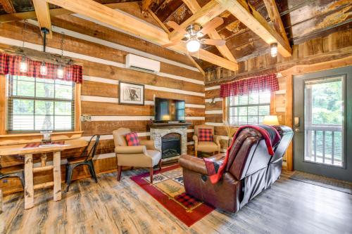 a log cabin living room with a fireplace and a table at Covered Deck and Fire Pit Smoky Mountain Cabin in Cosby