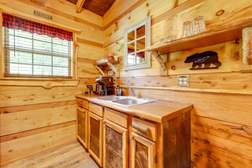 a kitchen with a sink in a wooden cabin at Covered Deck and Fire Pit Smoky Mountain Cabin in Cosby