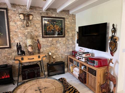 sala de estar con TV y pared de piedra en Casa Vacacional La Coruña en Culleredo
