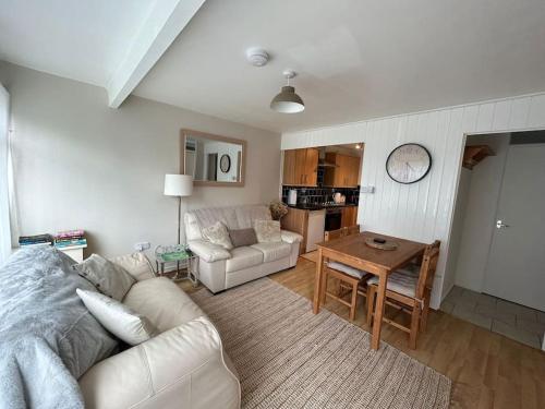 a living room with a white couch and a table at Cosy Chalet for Snowdonia in Caernarfon