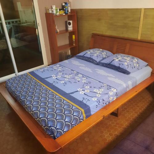a bed with a blue comforter and pillows on it at STUDIO FACE MARINA in Saint-François