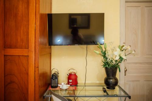 a glass table with a vase with flowers on it at Maison du comte in Mexico City
