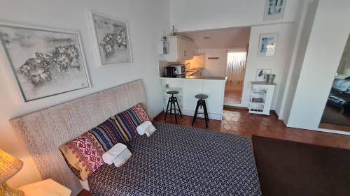 a living room with a couch and a kitchen at Musa Mar studio with balcony panoramic view in the residential area in Quarteira