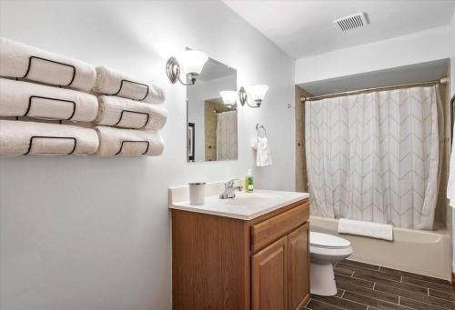 a bathroom with a sink and a toilet and towels at Serenity in the Suburbs: Your Gorgeous RVA Getaway in Richmond