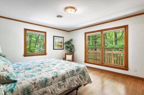 1 dormitorio con 1 cama y 2 ventanas en Serenity in the Suburbs: Your Gorgeous RVA Getaway en Richmond