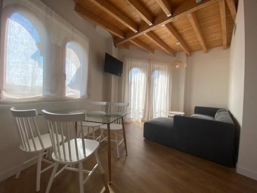 sala de estar con mesa, sillas y sofá en Apartamentos Palacio Alemar, en Loredo