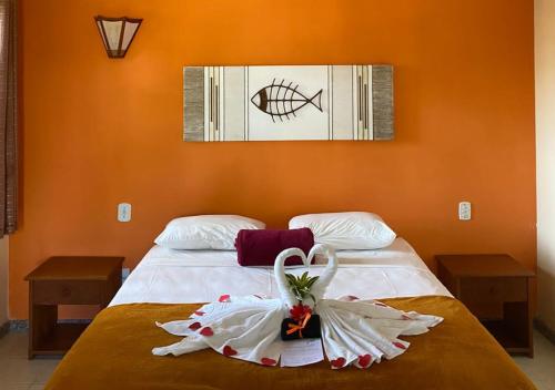 a bedroom with a bed with two white towels on it at Pousada Cantinho do Sossego in Arraial d'Ajuda