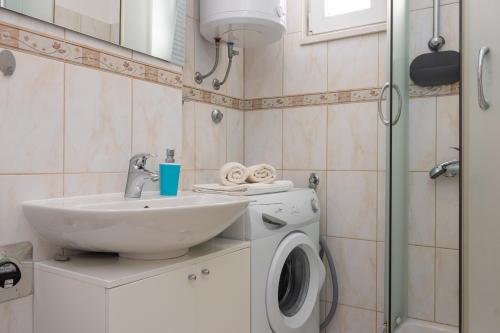 y baño con lavabo y lavadora. en Apartment Sunce 1-bedroom apartment in Split en Split