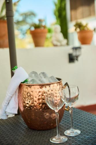 two wine glasses sitting next to a pot on a table at Casa el "Tablao de las Almendras" in Granada
