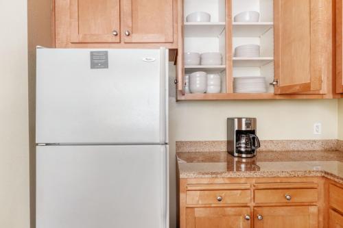 a white refrigerator in a kitchen with wooden cabinets at San Bruno 2br w pool spa gym nr groceries SFO-1398 in San Bruno