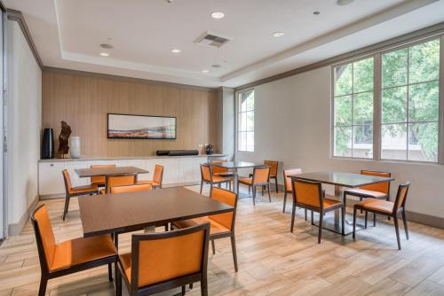 a dining room with tables and chairs and windows at San Bruno 2br w pool spa gym nr groceries SFO-1398 in San Bruno