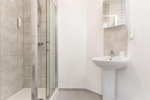 a bathroom with a sink and a shower at Plough Hotel in Northampton
