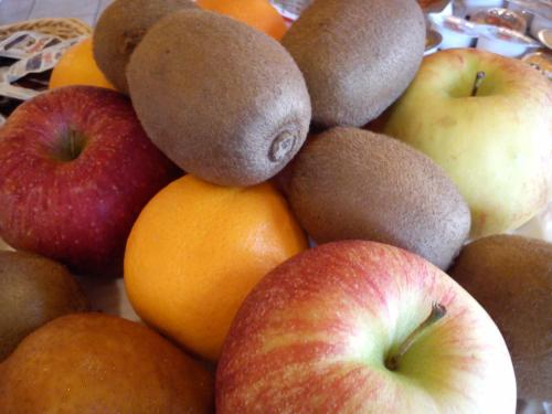 a pile of apples oranges and other fruits on a table at Country House La Perla del Sile in Sant'Elena di Silea