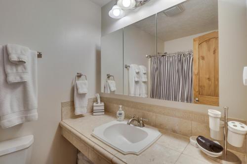 a white bathroom with a sink and a mirror at Wintergreen Home with Hot Tub, Deck and Mountain Views in Wintergreen