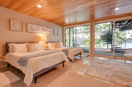 een slaapkamer met 2 bedden en een groot raam bij Immaculate, High-End Howell Villa on Pardee Lake! in Howell