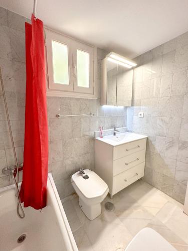 a bathroom with a white toilet and a red towel at Los Girasoles in Marina Botafoch in Ibiza Town