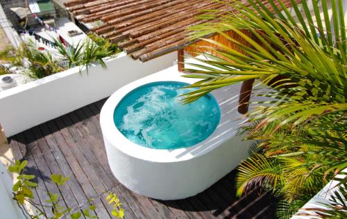 a bath tub on a deck with plants at Penthouse with private pool in Playa del Carmen