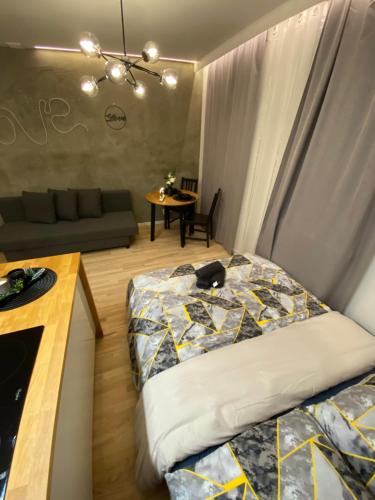 a bedroom with a bed and a couch and a table at Love Glow Studio in Krakow