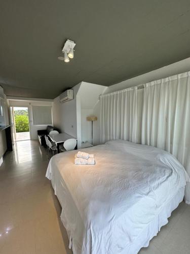 a bedroom with a large white bed and a desk at LINDABAYPLAYA STUDIO in Mar de las Pampas