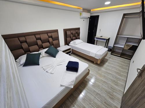 Habitación de hotel con 2 camas y balcón en Hostel Boutique Nido de Loros, en Medellín