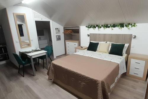 Schlafzimmer mit einem Bett, einem Tisch und einem Schreibtisch in der Unterkunft SantoSerenus in Ponta do Sol