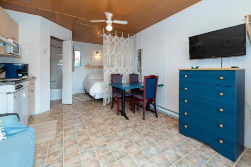 a dining room with a blue table and a bedroom at Navigateur Ste-Luce in Sainte-Luce-sur-Mer