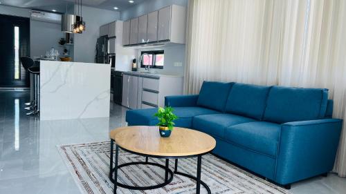 グランベにあるBlissful Villaの青いソファとテーブルのあるリビングルーム