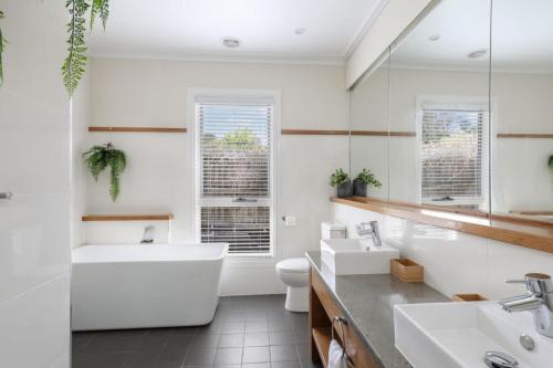 La salle de bains est pourvue de 2 lavabos, d'une baignoire et de toilettes. dans l'établissement Sofia Rose House only, à Katoomba