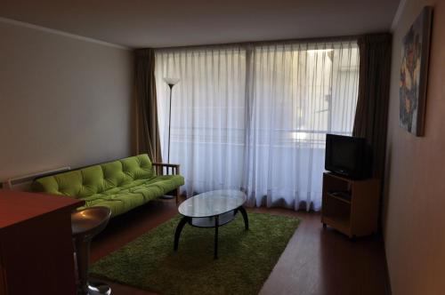 sala de estar con sofá verde y mesa en Apart Hotel Agustinas Plaza, en Santiago