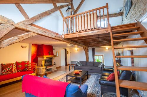 a living room with a loft with a staircase at Chateau de la Grange in Saint-Émiland