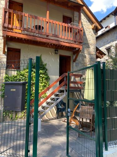 ベナスケにあるLa casa de las Ardillasの木製のデッキと門のある家