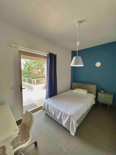 ein Schlafzimmer mit einem Bett, einem Fenster und einem Stuhl in der Unterkunft Villa Aspa in Nafplio