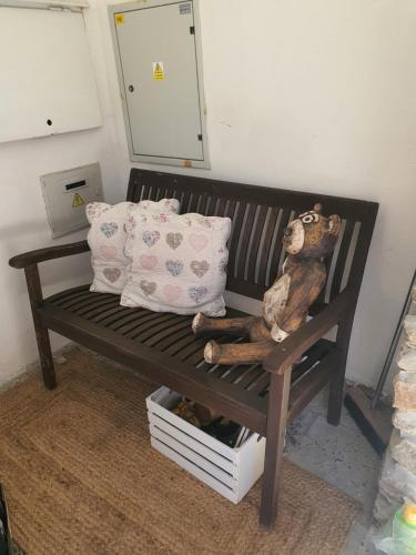 a stuffed bear sitting on a wooden bench with a pillow at Penzión Eva in Stará Voda