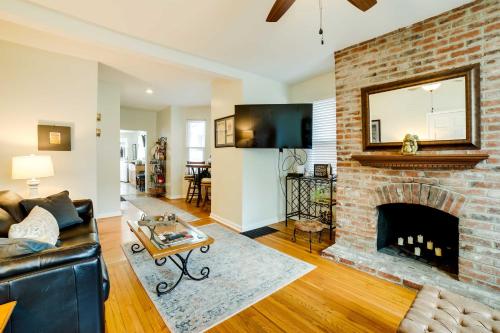 a living room with a brick fireplace with a mirror at Walk to Walnut St Shadyside House with Deck in Pittsburgh