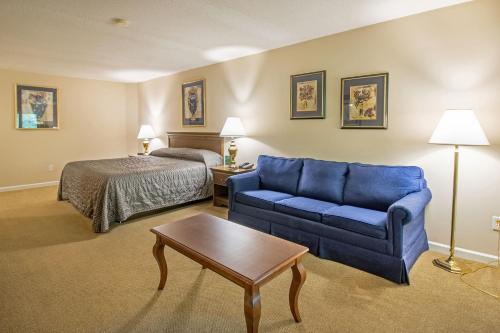 a hotel room with a blue couch and a bed at Massanuttens Shenandoah Villas by TripForth in McGaheysville