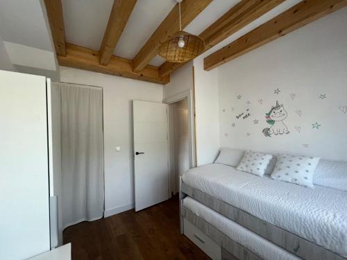 1 dormitorio con 1 cama en una habitación con techos de madera en EL PALOMAR DE GÜERRES, en Colunga