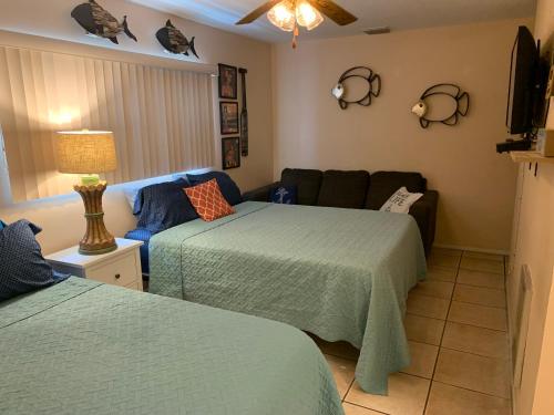 a living room with two beds and a couch at Michaels -Beachside Bungalows in St Pete Beach