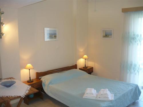 ein Schlafzimmer mit einem Bett mit zwei Handtüchern darauf in der Unterkunft Konsta Apartments in Kanali