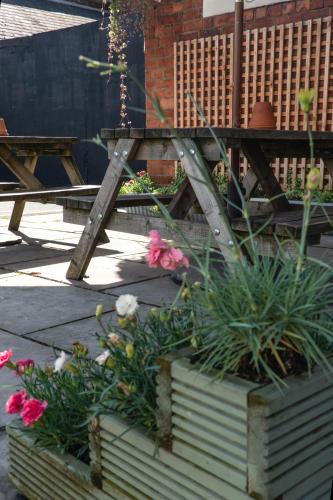 a picnic table and flowers in a garden at Plough Hotel in Northampton